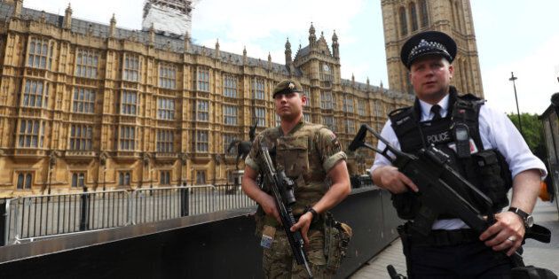 A soldier and police officer walk past the Houses of Parliament London, Britain May 24, 2017. REUTERS/Neil Hall