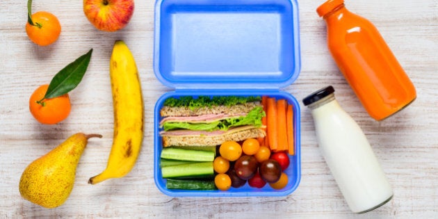 Blue Lunch Box with Sandwiches, Vegetables, Fruits and a Bottle of Milk in Top View