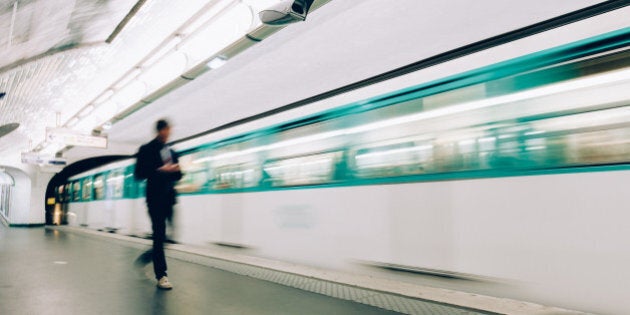 Man boarding train at metro station in Paris.