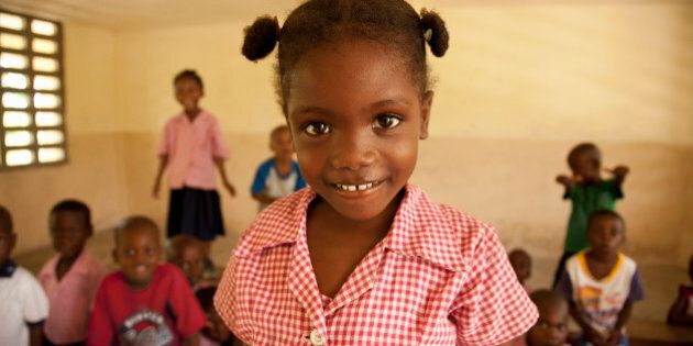 Young female 5-7 in Haiti smiling in her classroom