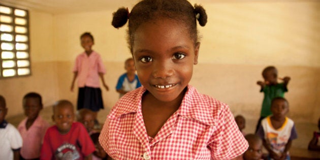 Young female 5-7 in Haiti smiling in her classroom