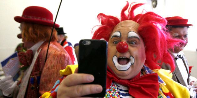 A clown takes a selfie at the All Saints Church hall before the Grimaldi clown service in Dalston, north London, February 7, 2016. The Clowns International 70th annual service brings together professional clowns from Britain and Europe in a service of remembrance to the famous British clown Joseph Grimaldi, who died in 1837. REUTERS/Peter Nicholls