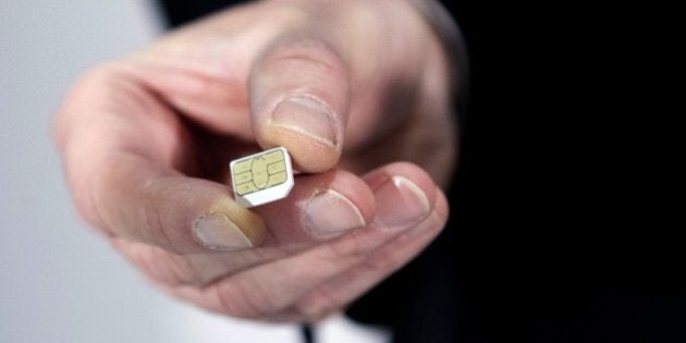 Gemalto CEO Olivier Piou shows a cell phone sim card before a press conference on February 25, 2015 in Paris. European SIM maker Gemalto said it had suffered hacking attacks that may have been conducted by US and British intelligence agencies but denied any 'massive theft' of encryption keys that could be used to spy on conversations. AFP PHOTO KENZO TRIBOUILLARD (Photo credit should read KENZO TRIBOUILLARD/AFP/Getty Images)