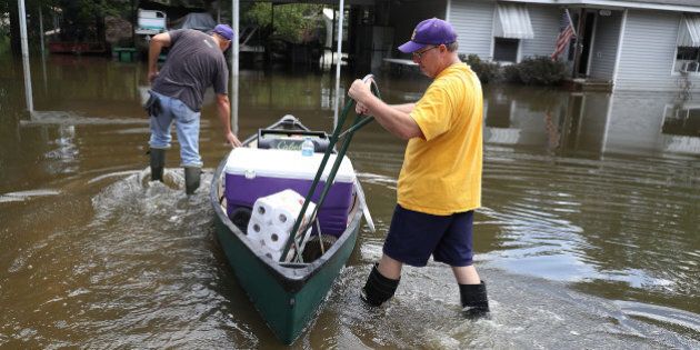 ST AMANT, LA - AUGUST 19: Mike Sittig (L) and Nelson Morgan jr. bring supplies to Nelson's fathers home to begin the process of cleaning up after flood waters inundated it on August 19, 2016 in St Amant, Louisiana. Last week Louisiana was overwhelmed with flood water causing at least thirteen deaths and thousands of homes damaged by the flood waters. (Photo by Joe Raedle/Getty Images)