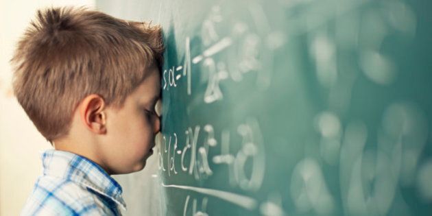 Little boy in math class overwhelmed by the math formula.