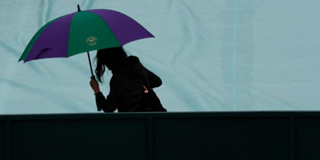 Britain Tennis - Wimbledon - All England Lawn Tennis & Croquet Club, Wimbledon, England - 29/6/16 General view of a spectator with an umbrella as rain delays play REUTERS/Stefan Wermuth