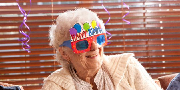 Senior woman with birthday glasses on