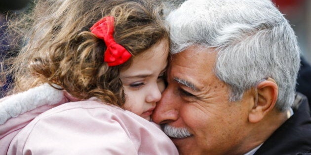 Hagop Manushian, a Syrian refugee who arrived earlier in the morning is reunited with his granddaughter Rita at the Armenian Community Centre of Toronto in Toronto, December 11, 2015. REUTERS/Mark Blinch