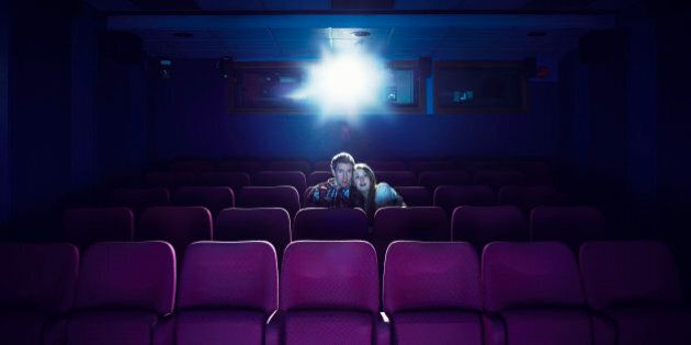 Couple watching a movie in an empty cinema