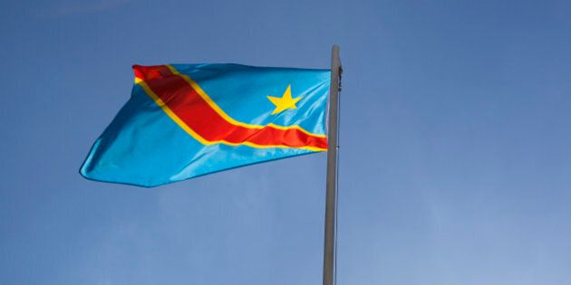 National flag of Congo on a flagpole in front of blue sky