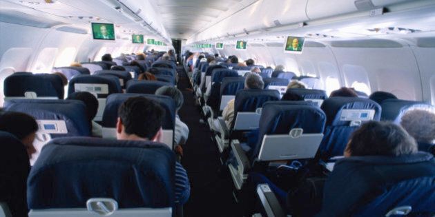 Passengers sitting in commercial airliner, rear view
