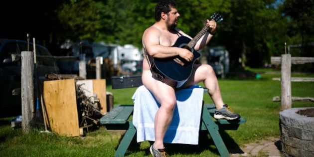 A man plays a guitar at the Bare Oaks Family Naturist park in Sharon June 18, 2011. The International Naturist Federation says