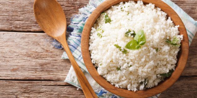 Cauliflower rice with basil close up in a bowl on the table. horizontal top view
