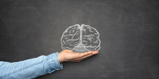 Brain and hand front of blackboard