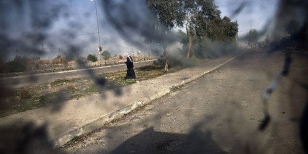 TOPSHOT - A picture taken through the bullet-riddled windshield of an Iraqi Counter Terrorism Service (CTS) Humvee shows a man crossing a street in eastern Mosul on January 10, 2017, during an ongoing military operation against the Islamic State (IS) group.Iraqi government forces launched a major offensive to recapture Mosul from the Islamic State group on October 17, 2016. Since then, they have retaken many areas in the eastern parts of Iraq's second city, but districts to the west of the Tigris River are still firmly in IS hands. / AFP / Dimitar DILKOFF (Photo credit should read DIMITAR DILKOFF/AFP/Getty Images)