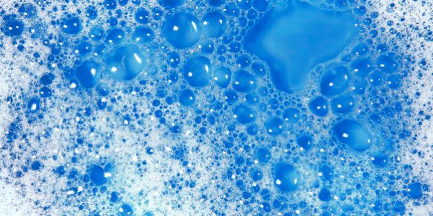Close-up of soap sud with water on a blue background.