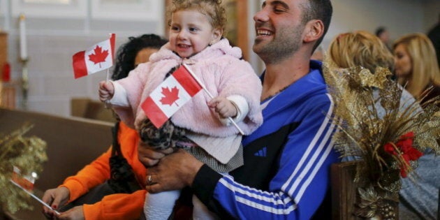 Syrian refugees Kevork Jamgochian holds his daughter Madlin at the St. Mary Armenian Apostolic Church during a welcome serivice at the Armenian Community Centre of Toronto in Toronto, December 11, 2015. REUTERS/Mark Blinch