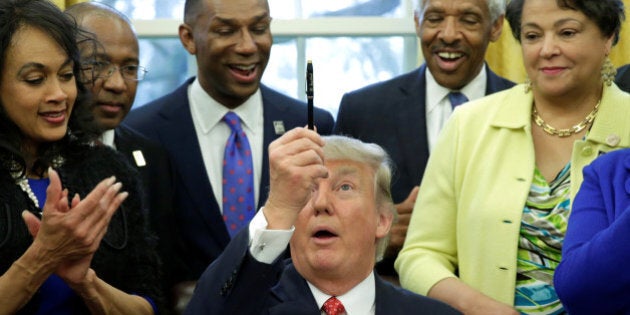 U.S. President Donald Trump holds up a pen after signing the HBCU executive order in the Oval Office of the White House, in Washington, DC, U.S. February 28, 2017. REUTERS/Yuri Gripas TPX IMAGES OF THE DAY