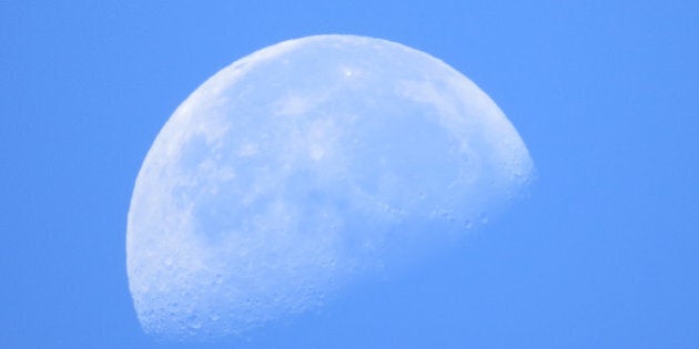 A bright moon in the clear blue sky