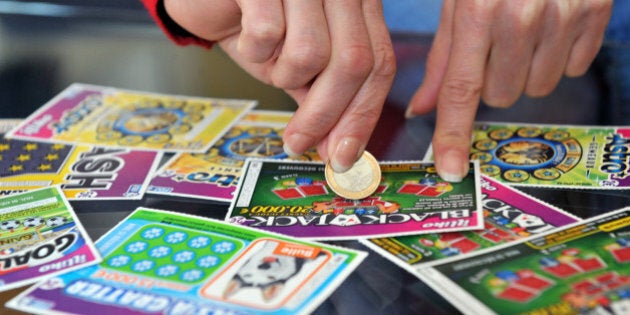 A player scratches a game card of the FranÃ§aise des Jeux (FDJ), the operator of France's national lottery, on May 28, 2013 in Nantes. AFP PHOTO / FRANK PERRY (Photo credit should read FRANK PERRY/AFP/Getty Images)