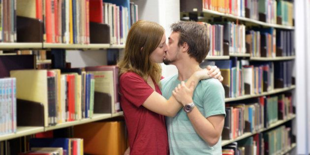 Heterosexual couple kissing in a library