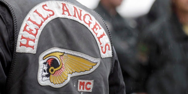 Police officers guard members of the rocker gang Hells Angels at the entrance of the district court in Duisburg, Germany, Monday, Aug. 30, 2010. A member of the Hells Angels is convicted of killing a member of the Bandidos, a rival rocker organization. (AP Photo/Frank Augstein)