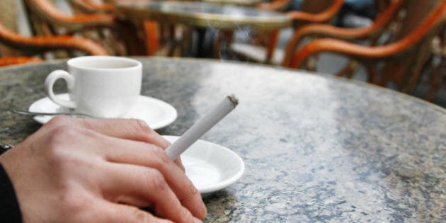 A man smokes a cigarette on the terrace of a bar 01 January 2008 in Bordeaux, southwestern France. France began 2008 under a new smoking ban in cafes and restaurants that drove smokers out into the street to light up their cigarettes as bar owners put away ashtrays. The ban signals a sizeable cultural shift for one of Europe's last smokers' bastions, particularly in Paris where cafe society and cigarettes have traditionally gone hand-in-hand. AFP PHOTO / JEAN-PIERRE MULLER (Photo credit should read JEAN-PIERRE MULLER/AFP/Getty Images)