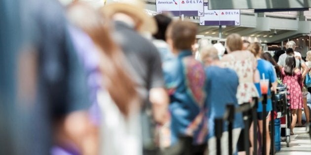 TORONTO, CANADA - AUGUST 8, 2016 : Passengers in line await updates from Delta airline employees at Pearson International airport, in Toronto, Canada on August 8, 2016. Passengers were left stranded, some for several hours, after a computer issue left the American air carrier's flights grounded across the globe. (Photo by Giordano Ciampini/Anadolu Agency/Getty Images)