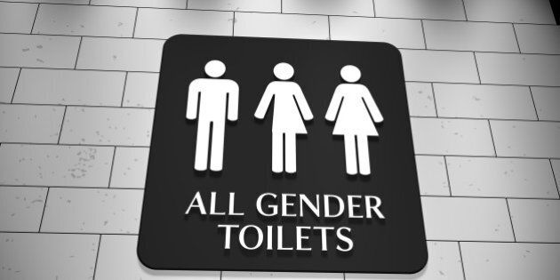 A sign on a wall for 'All Gender Toilets with symbols for men, trans and women. LGBT issue.