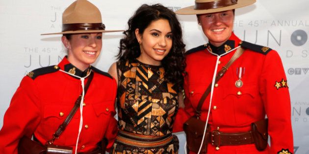 Juno nominee Alessia Cara poses with members of the Royal Canadian Mounted Police as she arrives on the red carpet for the 2016 Juno Awards in Calgary, Alberta, Canada, April 3, 2016. REUTERS/Chris Bolin