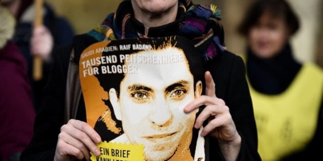 An Amnesty International activist holds a picture of Saudi blogger Raif Badawi during a protest against his flogging punishment on January 29, 2015 in front of Saudi Arabia's embassy to Germany in Berlin. The 30-year-old Saudi has been sentenced to 1,000 lashes for insulting Islam and is serving a 10-year jail term - a case which has drawn widespread international criticism. AFP PHOTO / TOBIAS SCHWARZ (Photo credit should read TOBIAS SCHWARZ/AFP/Getty Images)