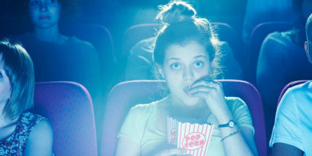 Woman enjoying movie at cinema