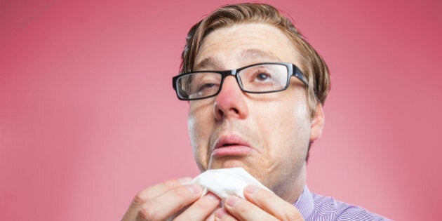 A nerdy businessman brushing his teeth isolated on a red background.