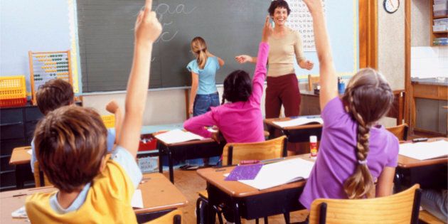 Children with raised hands in classroom