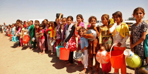 Displaced people from the minority Yazidi sect, fleeing violence in the Iraqi town of Sinjar west of Mosul, line up to receive food at the khanki camp on the outskirts of Dohuk province, September 13, 2014. REUTERS/Ari Jalal (IRAQ - Tags - - Tags: CIVIL UNREST CONFLICT SOCIETY TPX IMAGES OF THE DAY) FOR BEST QUALITY IMAGE ALSO SEE: GF2EA9Q0KPG01