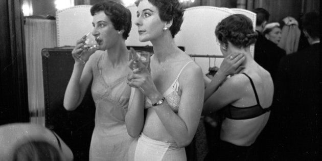 Backstage, British models enjoy a glass of champagne as they wait to change into clothes designed by John Cavanagh. The designer is in Paris with four British models to show off his work and win orders from international buyers who don't come to London.