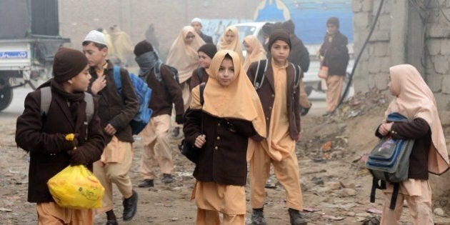 Pakistani children arrive at their school in Peshawar on December 20, 2014, after three days of mourning for the children and staff killed by Taliban militants in an attack on an army-run school. A Taliban massacre at a school is 'Pakistan's 9/11', the country's top foreign policy official told AFP, saying the assault that left 149 dead would change the country's approach to fighting terror. AFP PHOTO / A MAJEED (Photo credit should read A Majeed/AFP/Getty Images)