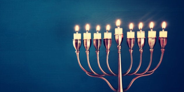 Image of jewish holiday Hanukkah background with menorah (traditional candelabra) and burning candles