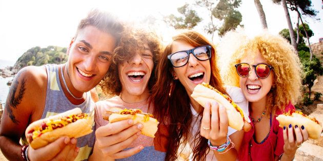 Friends enjoying having hotdogs together