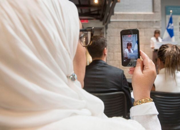 A woman records on her phone as Quebec Immigration, Diversity and Inclusiveness Minister Kathleen Weil makes an announcement about the fight against systemic discrimination and racism on July 20, 2017 in Montreal.THE CANADIAN PRESS/Ryan Remiorz