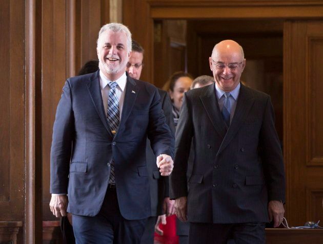Le premier ministre du Québec, Philippe Couillard, et le ministre des Transports, Jacques Daoust, sourient alors qu'ils se rendent à une conférence de presse pour commenter l'entente entre la CSeries de Bombardier et Delta Airlines le 28 avril 2016, à Québec. (LA PRESSE CANADIENNE/Jacques Boissinot)