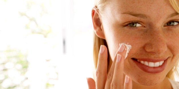 Woman applying skin cream