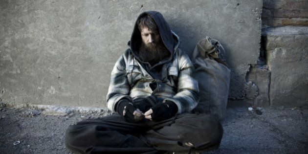 USA, Utah, Salt Lake City, Homeless man with sack sitting on sidewalk