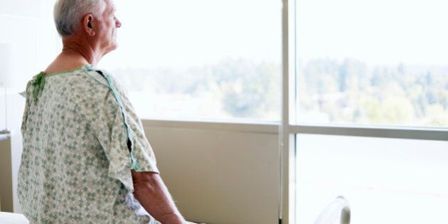 Senior male patient looking out window in hospital