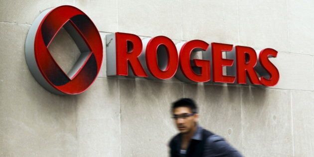 A man walks past a Rogers sign on the day of the Rogers Communications Inc. annual general meeting for shareholders in Toronto, April 21, 2015. REUTERS/Mark Blinch