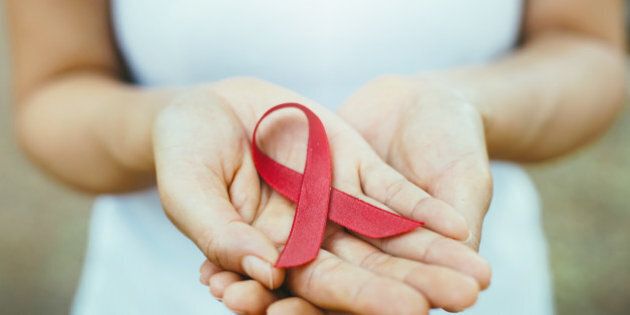 red aids ribbon in hand. soft focus on ribbon