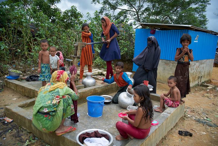 Des femmes et des enfants sont rassemblés au point d'eau afin de se laver, de faire la lessive et de puiser de l'eau potable au camp de fortune Kutupalong pour personnes réfugiées rohingyas, au Bangladesh. © UNICEF/UN069113/Noorani