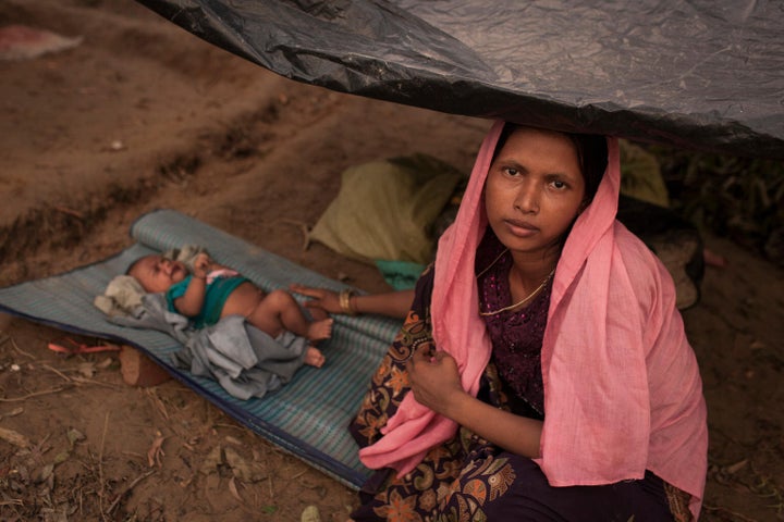 Des familles de réfugiés rohingyas s'apprêtent à construire un abri improvisé au camp de fortune Kutupalong pour personnes réfugiées rohingyas, au Bangladesh.