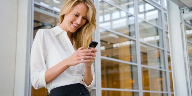 Smiling businesswoman texting