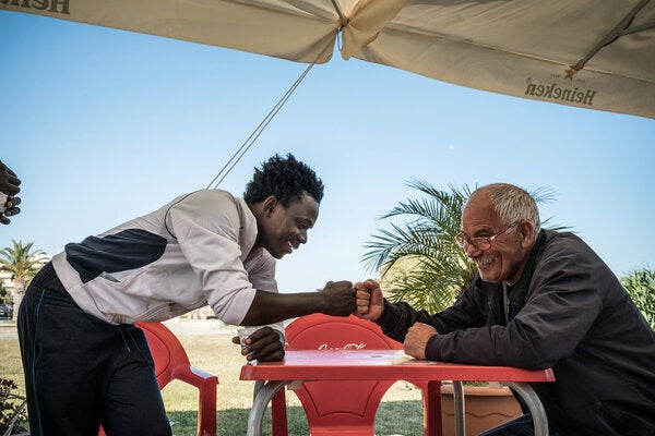 Mohammad, âgé de 17 ans, sympathise avec un Italien, lors d'une sortie du centre de réception pour les demandeurs d'asile qui sert également de centre d'hébergement pour les mineurs non-accompagnés, dans le port de Pozzallo, Sicile, en Italie (Mai 2016).